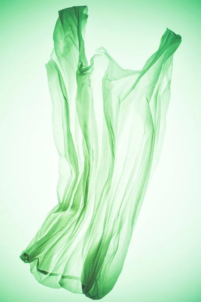 Saco de plástico transparente sob luz verde colorida — Fotografia de Stock