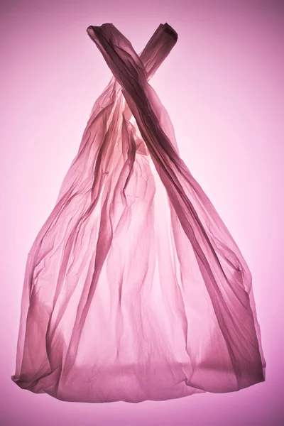 Crumpled transparent plastic bag under pink toned light — Stock Photo