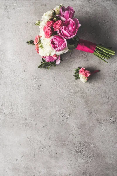 Vista dall'alto del bouquet da sposa e boutonniere sulla superficie grigia — Foto stock
