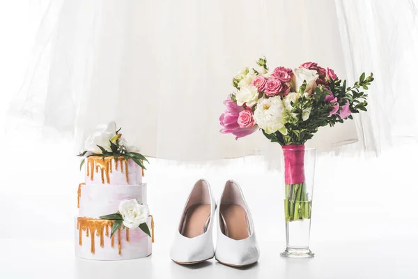 Pastel de boda con zapatos, vestido y ramo aislado en blanco - foto de stock