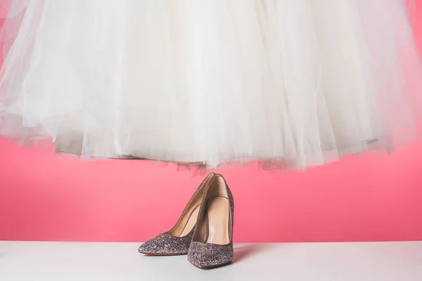 Par de zapatos y vestido de novia aislado en rosa - foto de stock