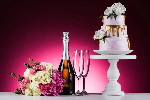 Ramo de bodas, champán con copas y pastel en el stand en rosa - foto de stock
