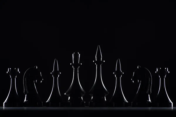 Silhouettes de figures d'échecs isolées sur noir, concept d'affaires — Photo de stock