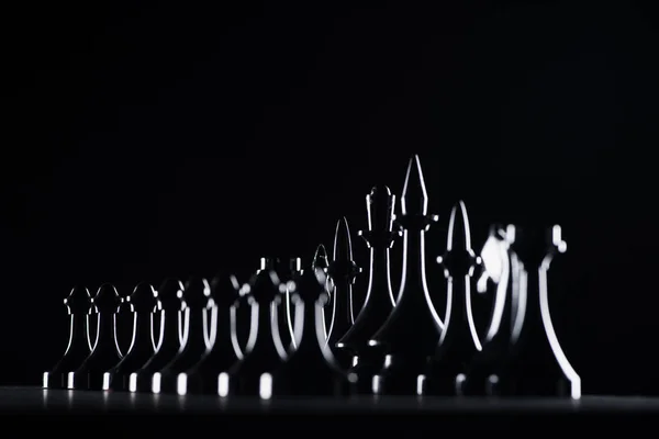 Silhouettes de figures d'échecs isolées sur noir, concept d'affaires — Photo de stock