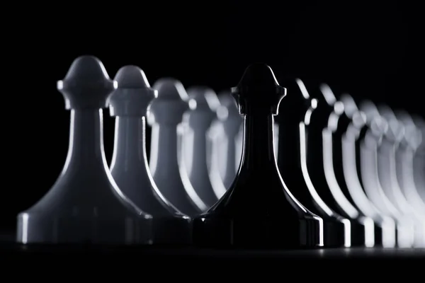 Rows of white and black chess figures isolated on black, business concept — Stock Photo