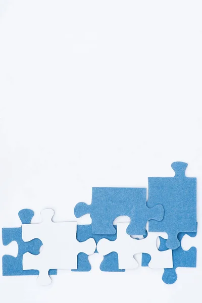 Vue de dessus des puzzles blancs et bleus isolés sur blanc, concept d'entreprise — Photo de stock
