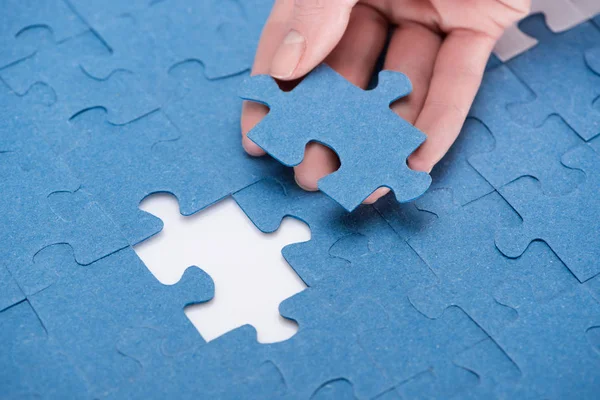 Cropped image of businesswoman inserting last missing puzzle, business concept — Stock Photo