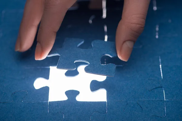 Cropped image of businesswoman inserting last missing puzzle, business concept — Stock Photo