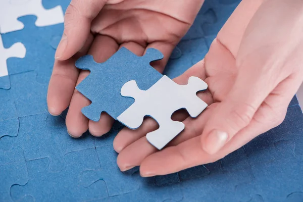 Abgeschnittenes Bild einer Geschäftsfrau, die blaue und weiße Puzzles zusammenfügt, Geschäftskonzept — Stockfoto