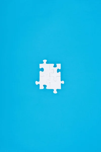 Top view of assembled white puzzles isolated on blue, business concept — Stock Photo