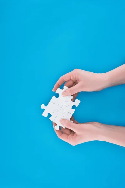 Cropped image of businesswoman holding assembled puzzles isolated on blue, business concept — Stock Photo