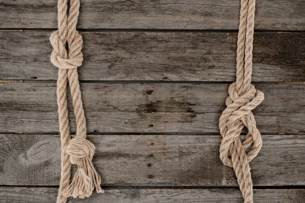 Flache Lage mit Seeseilen mit Knoten auf Grunge-Holztischplatte — Stockfoto