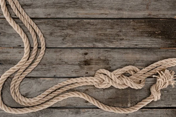 Flat lay with marine ropes with knots on grunge wooden tabletop — Stock Photo