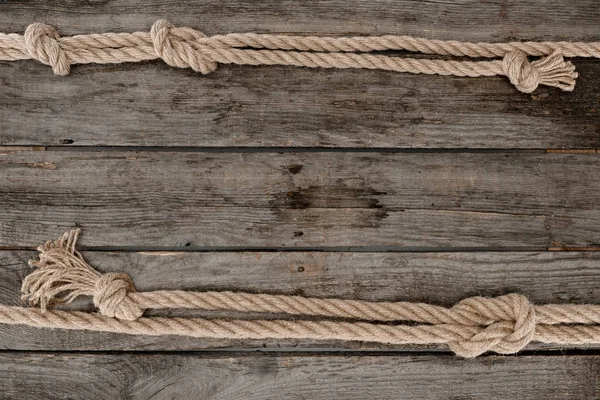 Плоска лежала з морськими мотузками з вузлами на гранжевій дерев'яній стільниці — стокове фото