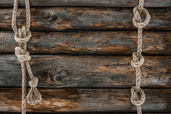 Flat lay with marine ropes with knots on grunge wooden tabletop — Stock Photo