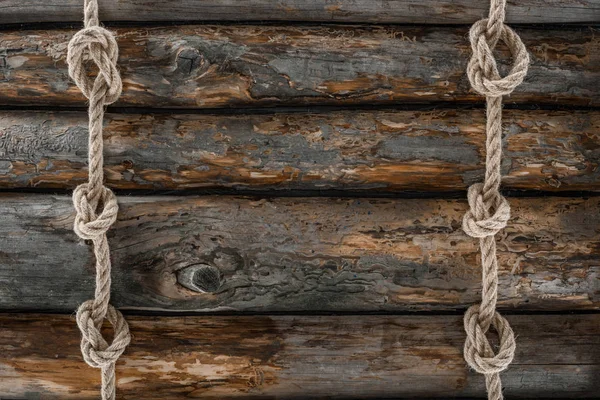 Плоский ліжко з розставленими морськими мотузками з вузлами на гранжевому дерев'яному стільниці — стокове фото