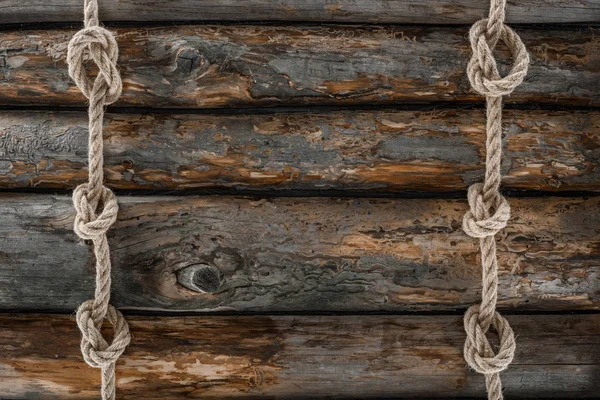 Flat lay with arranged marine ropes with knots on grunge wooden tabletop — Stock Photo