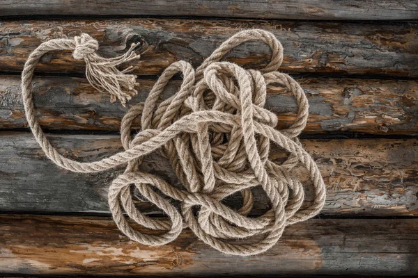 Top view of nautical rope with knot on grunge wooden surface — Stock Photo