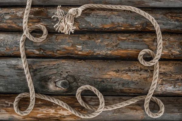 Top view of nautical rope with knot on grunge wooden surface — Stock Photo