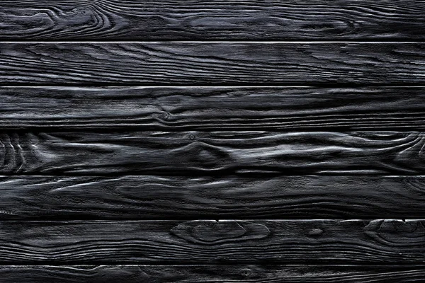 Wooden horizontal planks painted in black background — Stock Photo