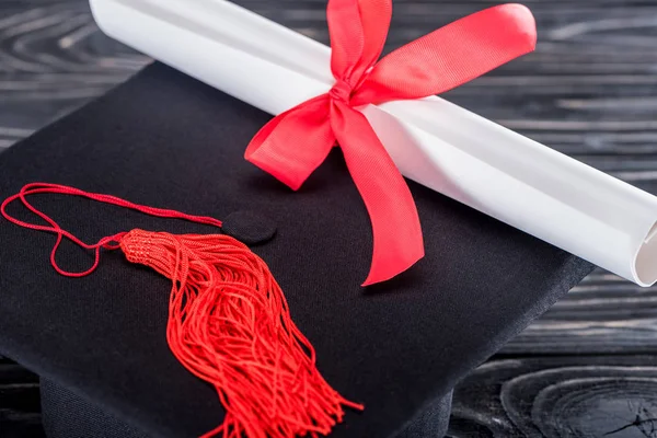 Concetto di istruzione con diploma e tappo di laurea su tavolo in legno — Foto stock