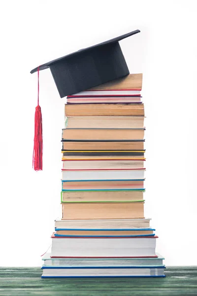 Graduierungskonzept mit gestapelten Büchern und Abschlussmütze — Stockfoto
