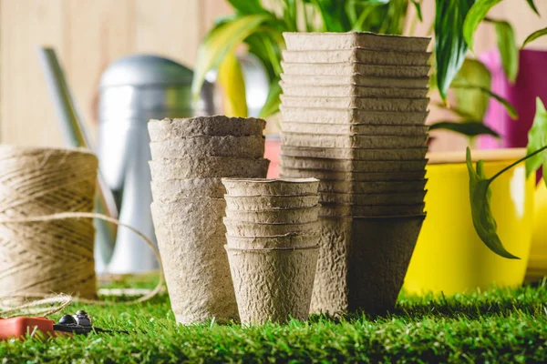 Closeup shot of stacks of different flower pots on grass — Stock Photo