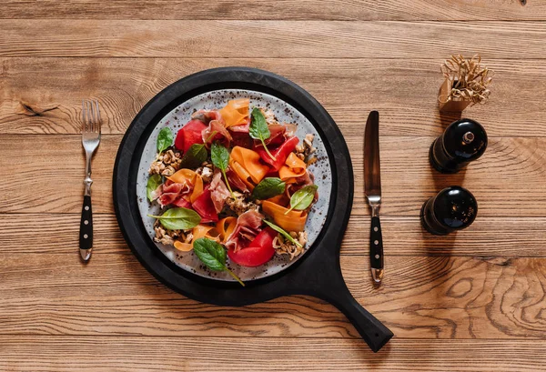 Vista superior de deliciosa ensalada con mejillones y verduras en mesa de madera - foto de stock