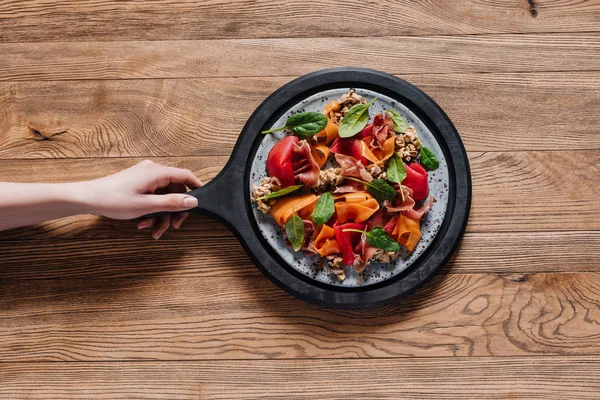 Teilansicht von Menschenhand und köstlichem Salat mit Miesmuscheln und Gemüse — Stockfoto