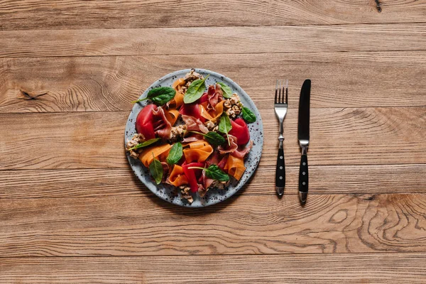 Vista superior de la ensalada gourmet con mejillones, verduras y jamón en la mesa de madera - foto de stock
