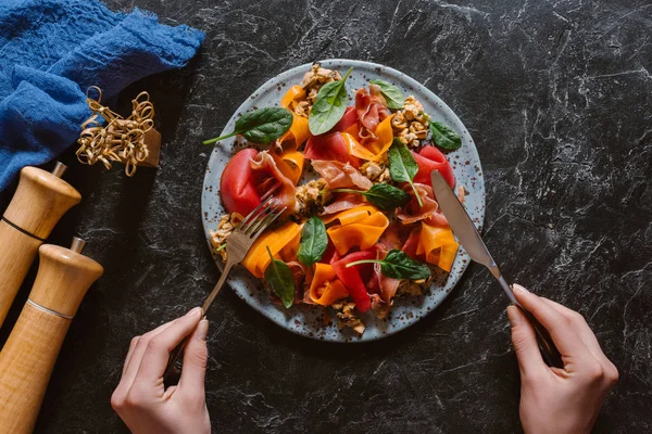 Picada de persona comiendo deliciosa ensalada con mejillones, verduras y jamón - foto de stock