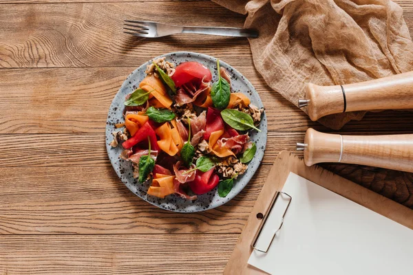 Blick von oben auf köstlichen Salat mit Miesmuscheln, Wurzelgemüse und Marmelade auf Holztisch — Stockfoto