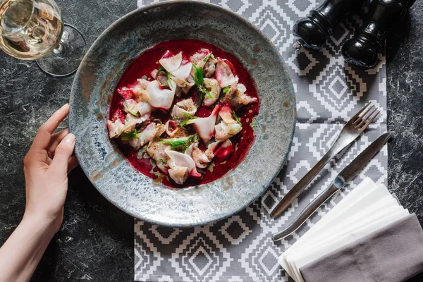 Cropped shot of human hand and delicious snack with dorado on marble table top — Stock Photo