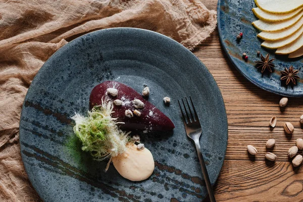 Draufsicht auf das Gourmet-Dessert mit Birne im Wein mit karamellisierten Pistazien — Stockfoto