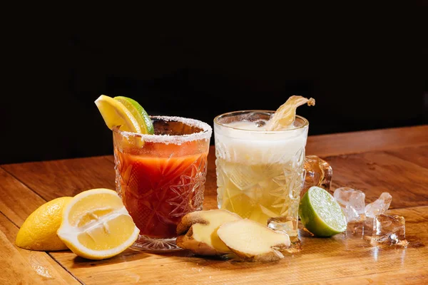 Verres avec comptoir de cocktails alcoolisés sur table en bois, Mary sanglante et gingembre ongles cocktails — Photo de stock