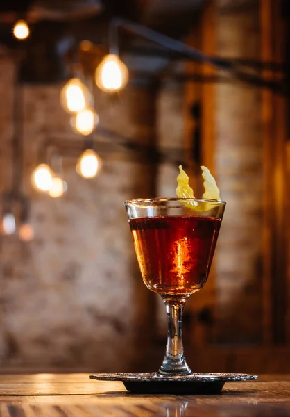 Vue rapprochée du cocktail sazerac alcoolisé en verre sur table en bois — Photo de stock