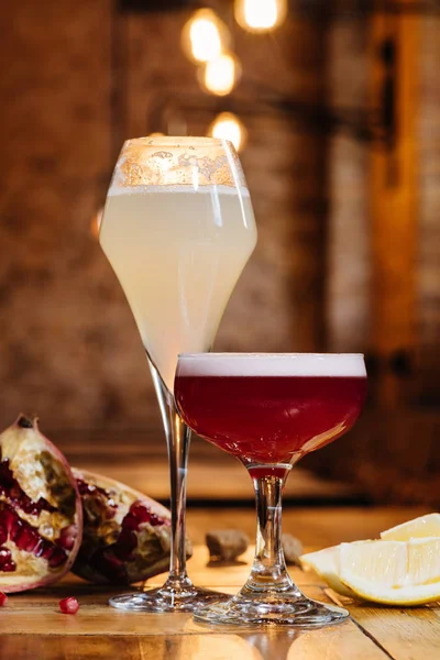 Крупный план бокалов с алкогольными коктейлями на деревянном столе — стоковое фото