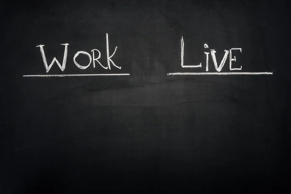 Work and Live underlined inscription on dark chalkboard — Stock Photo