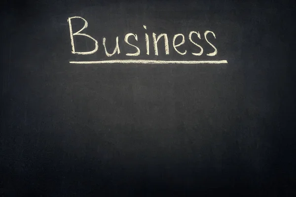 Business underlined inscription on dark chalkboard — Stock Photo