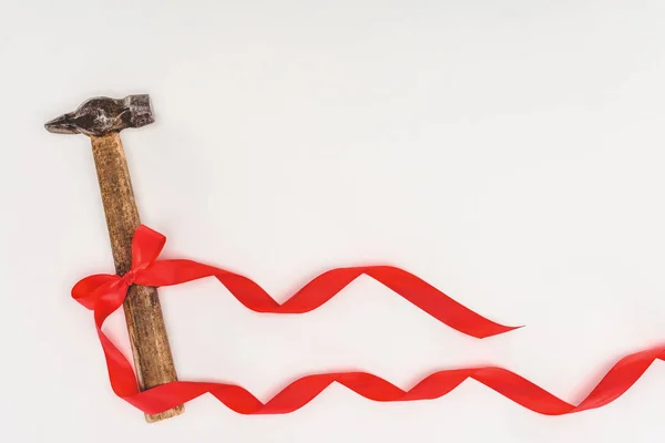 Top view of hammer wrapped by red ribbon isolated on white — Stock Photo