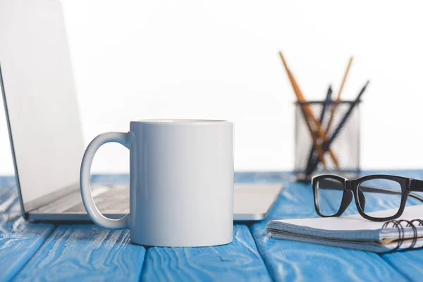 Gros plan de tasse, lunettes sur le manuel, ordinateur portable et organisateur avec stylos et crayons — Photo de stock
