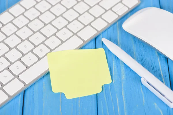 Gros plan de papier de note vide, stylo, clavier d'ordinateur et souris sur la surface en bois bleu — Photo de stock