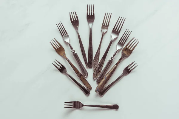 Composição de antigos garfos de metal no fundo branco — Fotografia de Stock