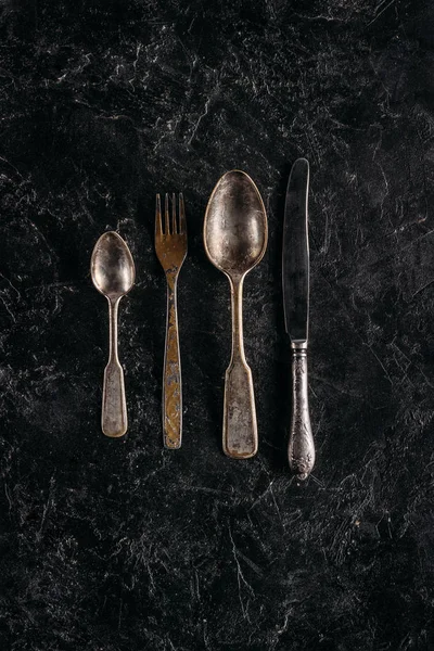 Old rusted silverware set on dark marble table — Stock Photo