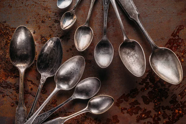 Old metal spoons on rusted background — Stock Photo