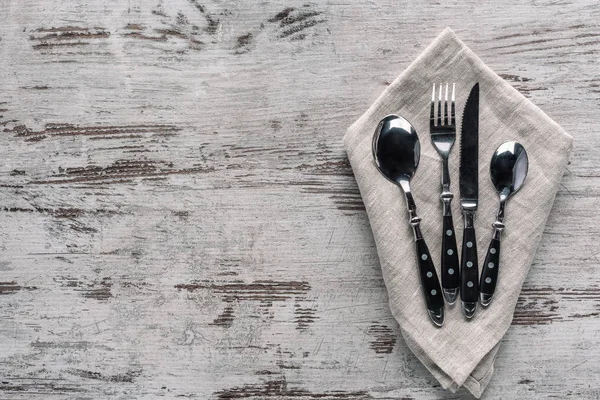 Set of dinner silverware with napkin on wooden table — Stock Photo