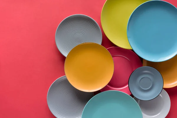 Colorful plates composition on red background — Stock Photo