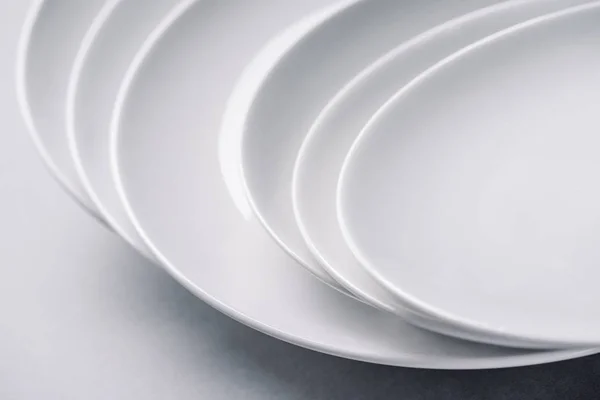 White ceramic plates stacked on white background — Stock Photo