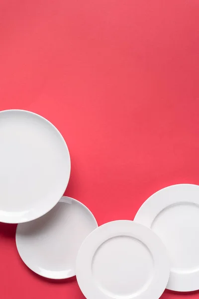 Composition of white plates on red background — Stock Photo