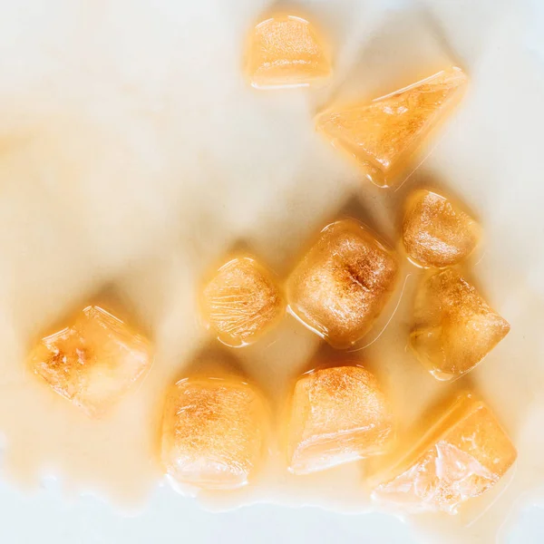 Vue de dessus de glaçons bruns en café sur plateau blanc — Photo de stock